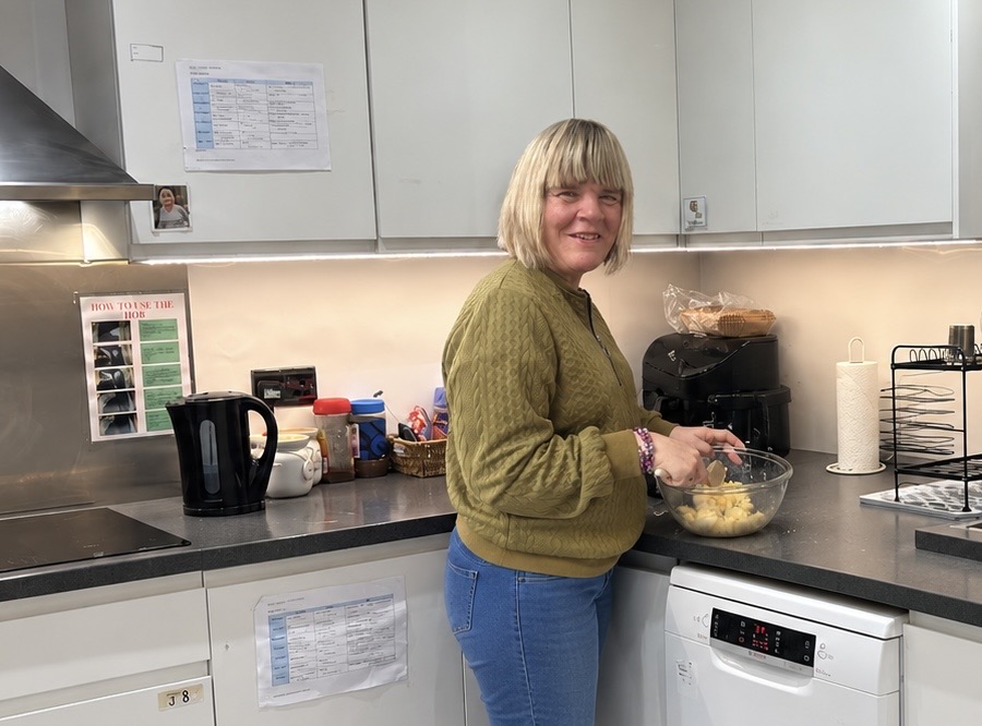 A resident of Gow Lodge with her support worker in the communal lounge